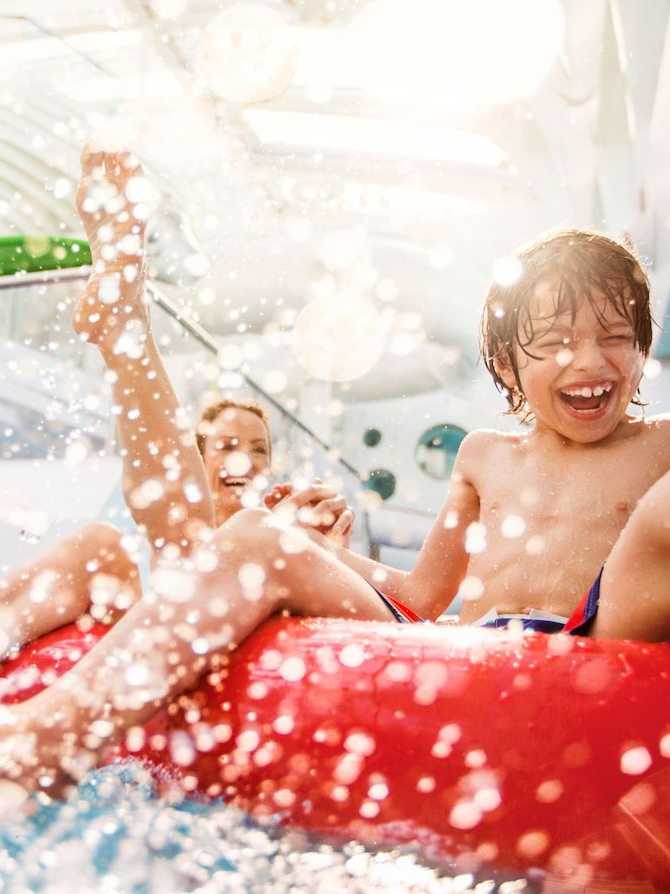 AIDA Cruises buchen - Wasserspaß für die ganze Familie – Abenteuer und Entspannung an Bord Lachender Junge beim Wasserspaß auf einer Kreuzfahrt mit AIDA Cruises