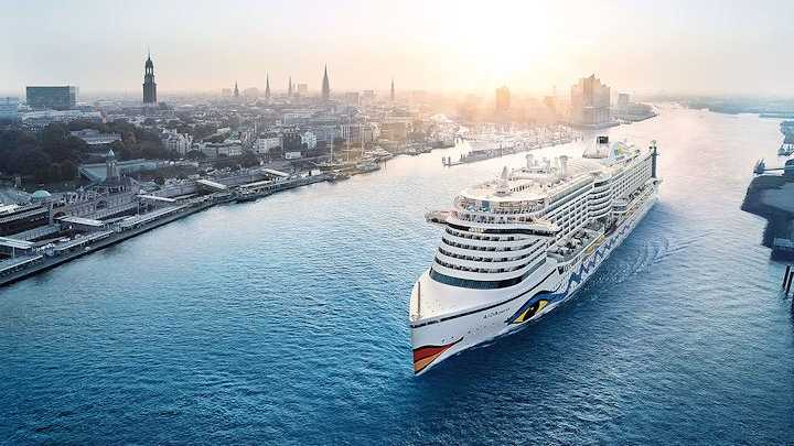 Kreuzfahrtschiff von AIDA Cruises auf der Elbe in Hamburg Ein Kreuzfahrtschiff von AIDA Cruises auf der Elbe in Hamburg vor der Skyline der Stadt.