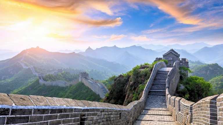 Chinesische Mauer schlängelt sich über grüne Hügel im warmen Morgenlicht