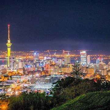 Skyline von Auckland, Neuseeland bei Nacht mit beleuchtetem Sky Tower