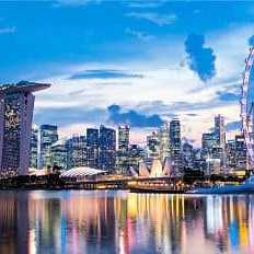 Skyline von Singapur mit Marina Bay Sands, Singapore Flyer und Wasserreflektion bei Sonnenuntergang
