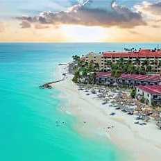 Karibischer Strand mit türkisfarbenem Meer und Hotelanlage auf Aruba