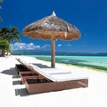 Sonnenliegen unter Palmen am weißen Sandstrand auf Bali