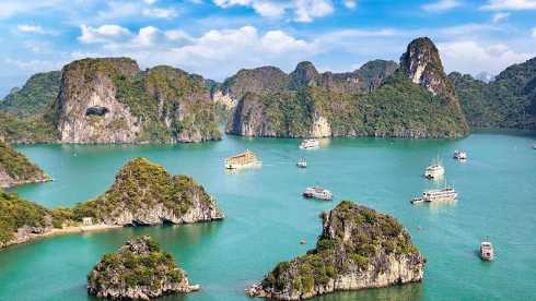 Vietnam: Halong-Bucht mit Kalksteinfelsen und Booten auf smaragdgrünem Wasser