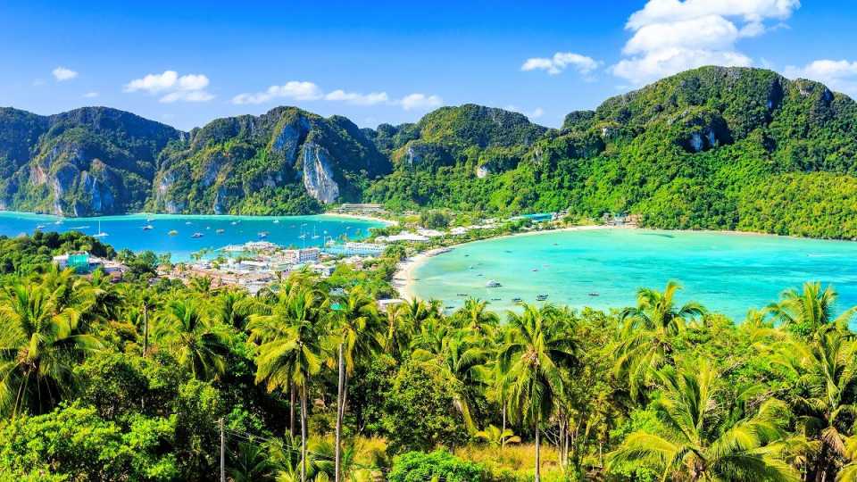 Blick auf eine tropische Doppelbucht mit türkisblauem Wasser, Sandstränden und grünen Felsen – Rundreise und baden in Thailand.