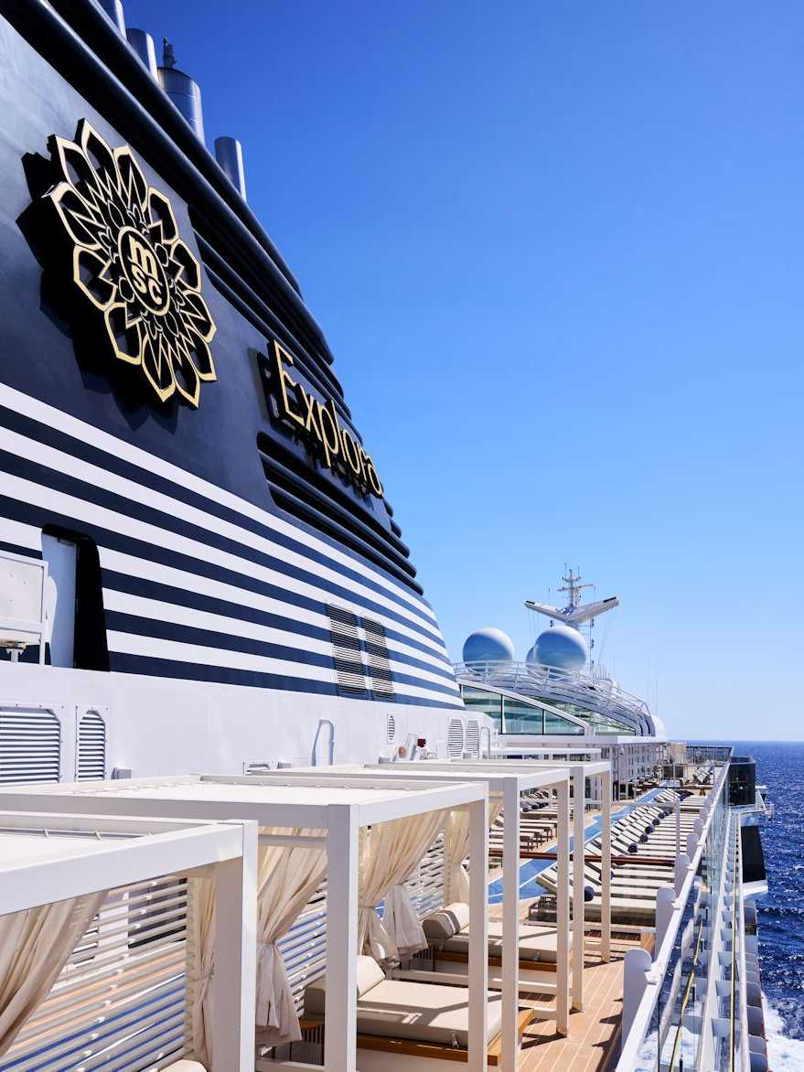 Luxus auf hoher See – MSC Explora buchen Deckbereich des MSC Explora II mit luxuriösen Lounge-Betten und Blick auf das Meer