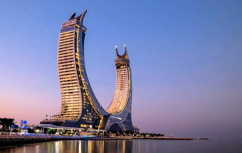 Luxus-Kombireise Katar: Die futuristische Architektur des Raffles Doha in den Katara Towers bei Sonnenuntergang – exklusive Horizonte der Exzellenz von JUREBU.