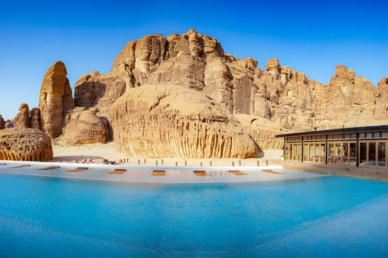 Saudi-Arabien Luxusreise AlUla exklusiver Pool vor monumentalen Sandsteinfelsen und moderner Architektur